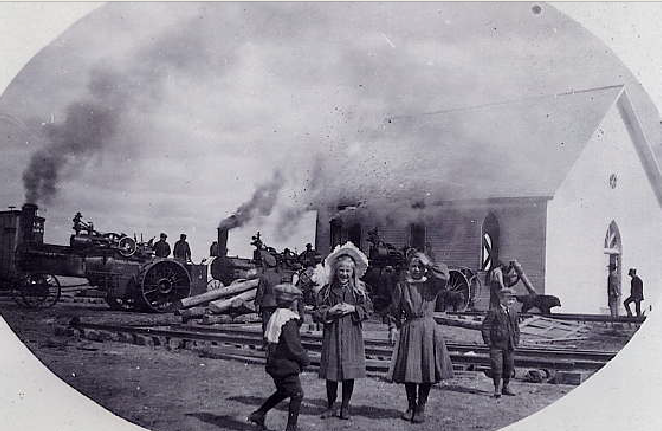 A church amongst a few other houses is being shown with the words 'Wolseley Sask' at the bottom of the photo.
