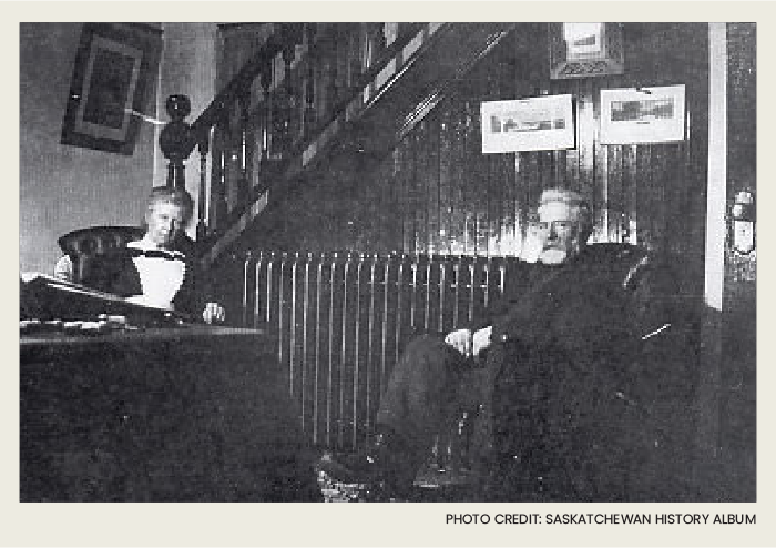 The outside of the house has a car parked next to it and a group of people sitting on the front porch.