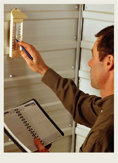 Photo caps-02 A man is checking the temperature in a chicken barn.