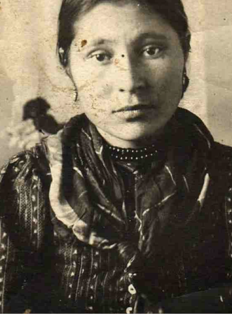A photo of a young First Nations woman wearing traditional clothing is shown.