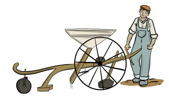 A farmer is wearing overalls to work with a small seeder. 