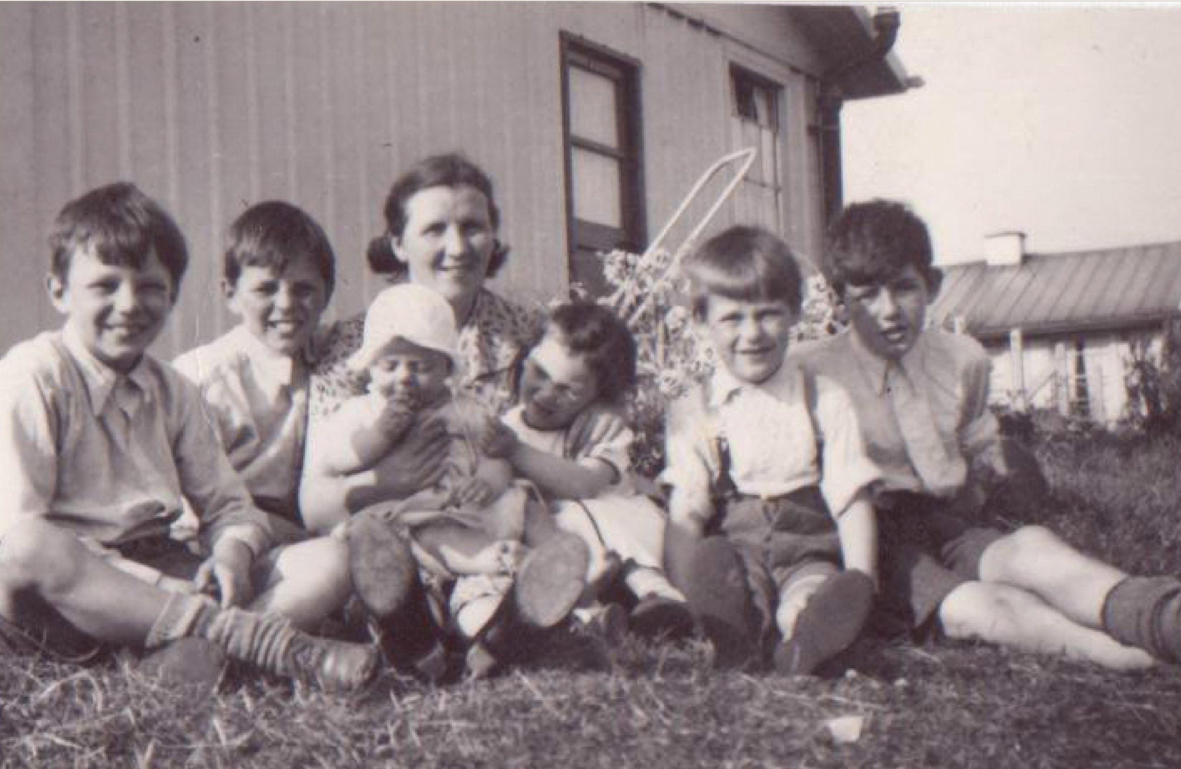 A train is stopped in a small town next to a train station and two elevators.