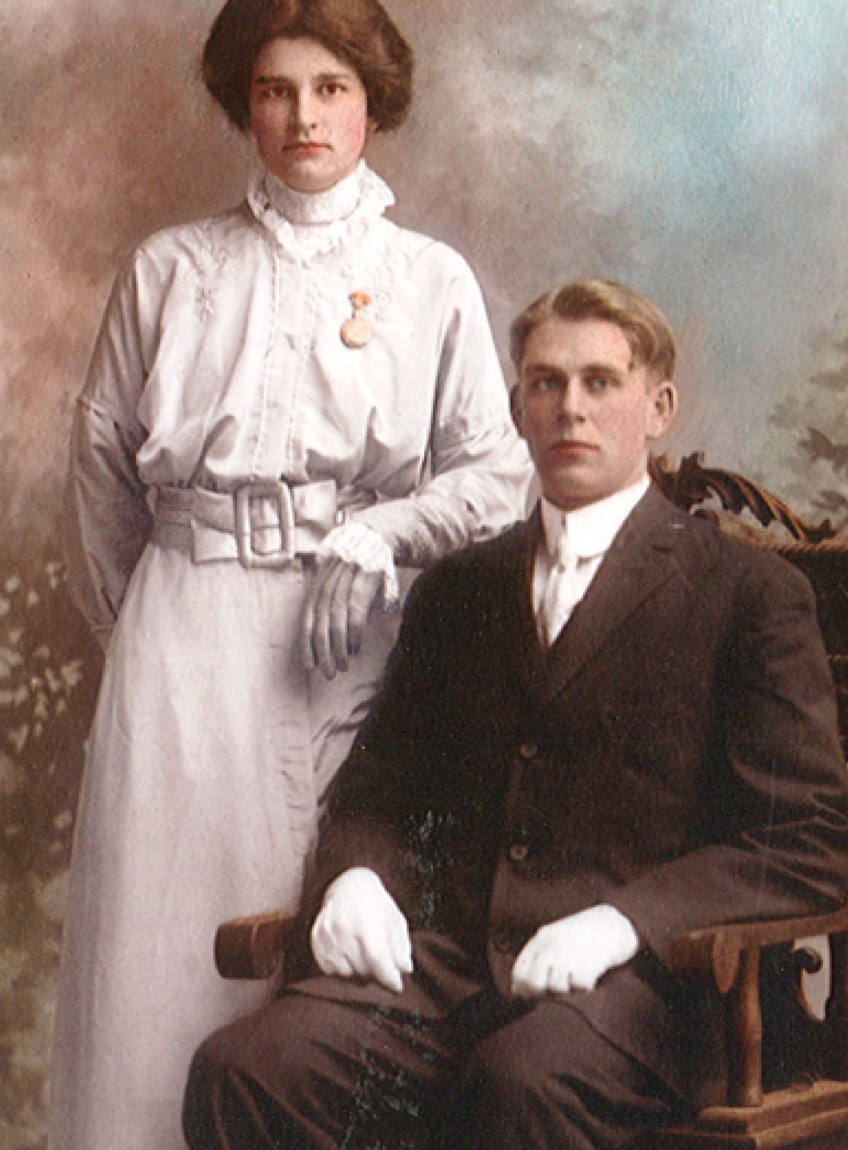 A Mennonite couple are dressed up and posing for a photo.