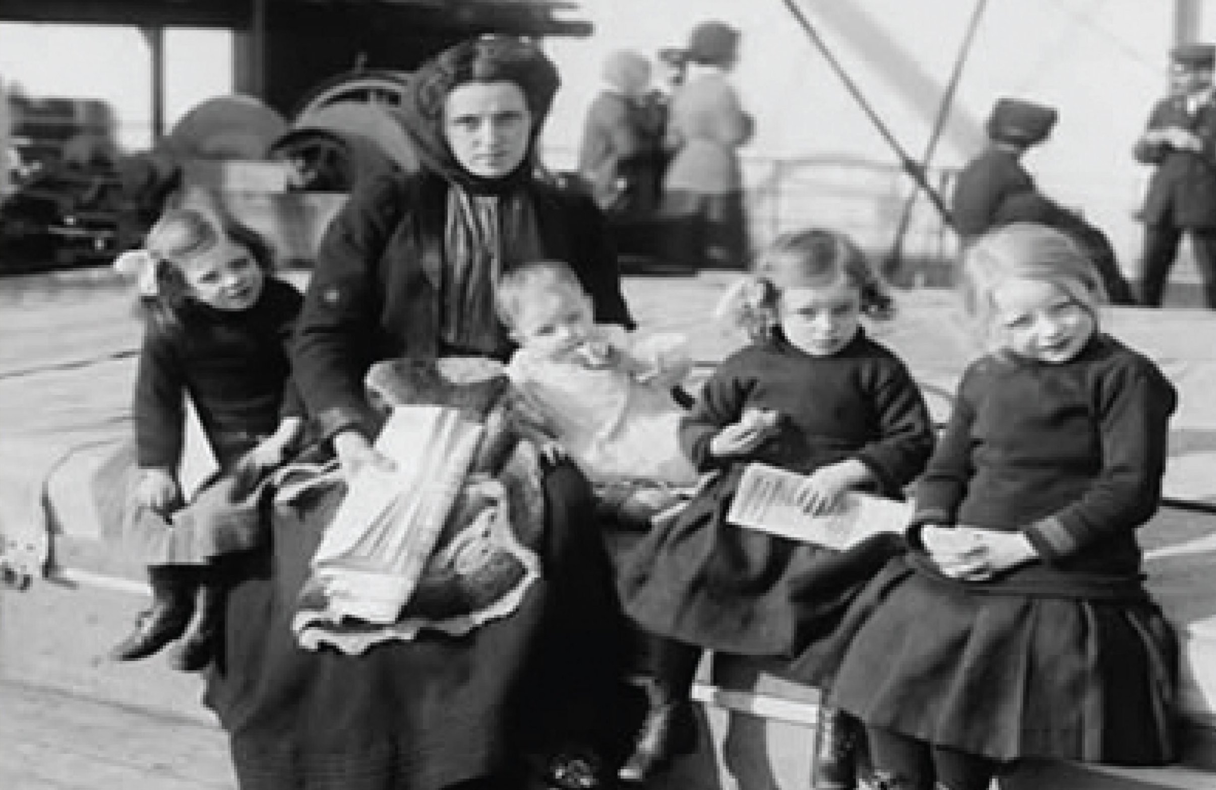 A train is stopped in a small town next to a train station and two elevators.