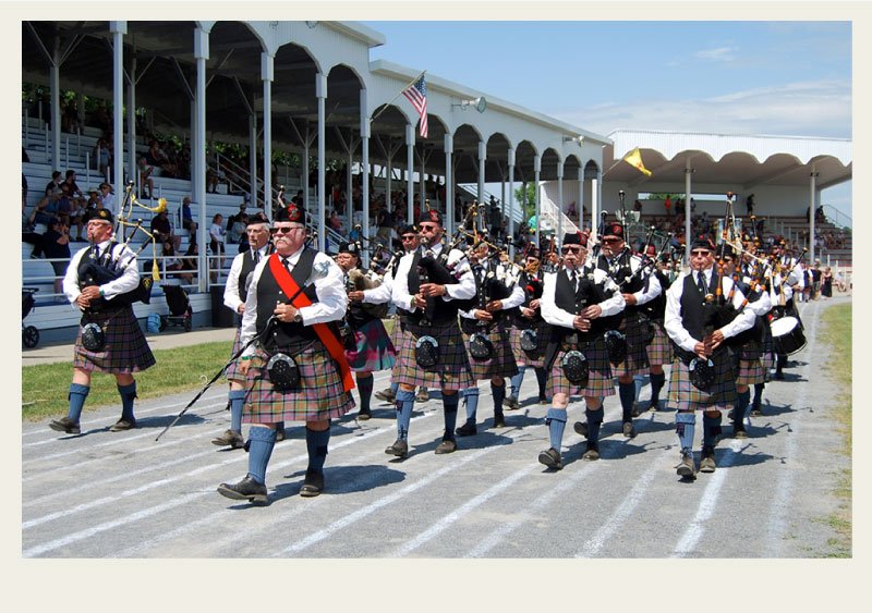 A band of pipe band players march together during an opening ceremony for the Highland games.