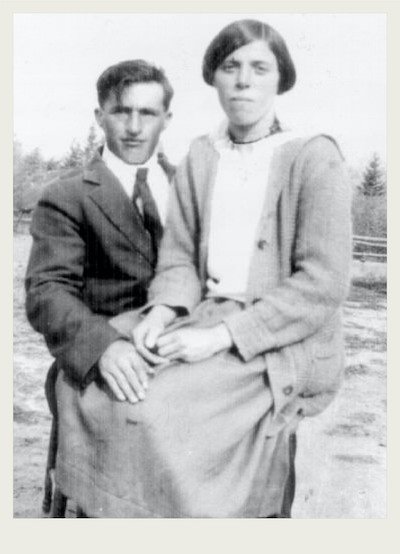 A young Ukrainian couple sits together to pose for a photo in a farm yard.