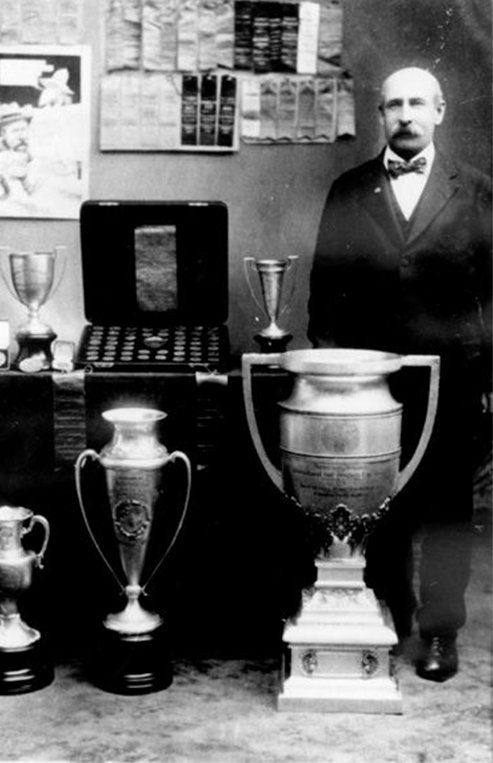 A slice of cheesecake is on a plate with Saskatoon berries on top.