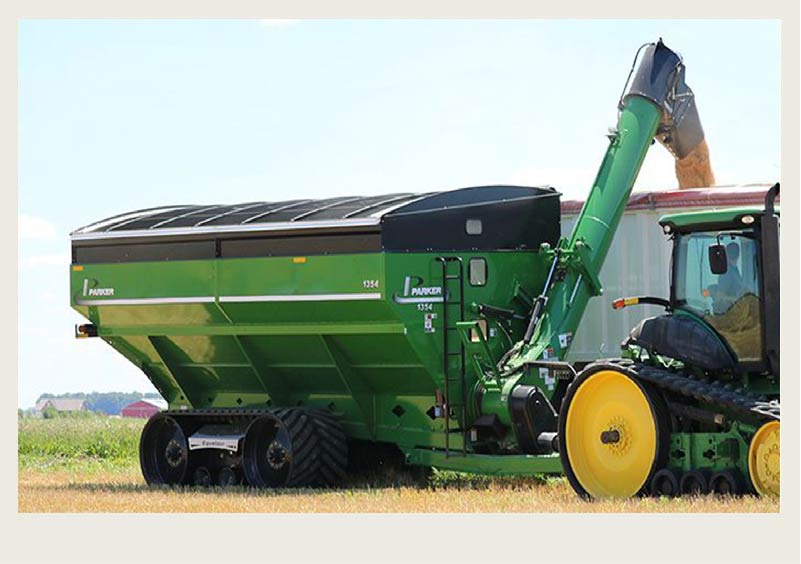 A grain cart unloads grain into a grain truck for It to be put into a grain bin.