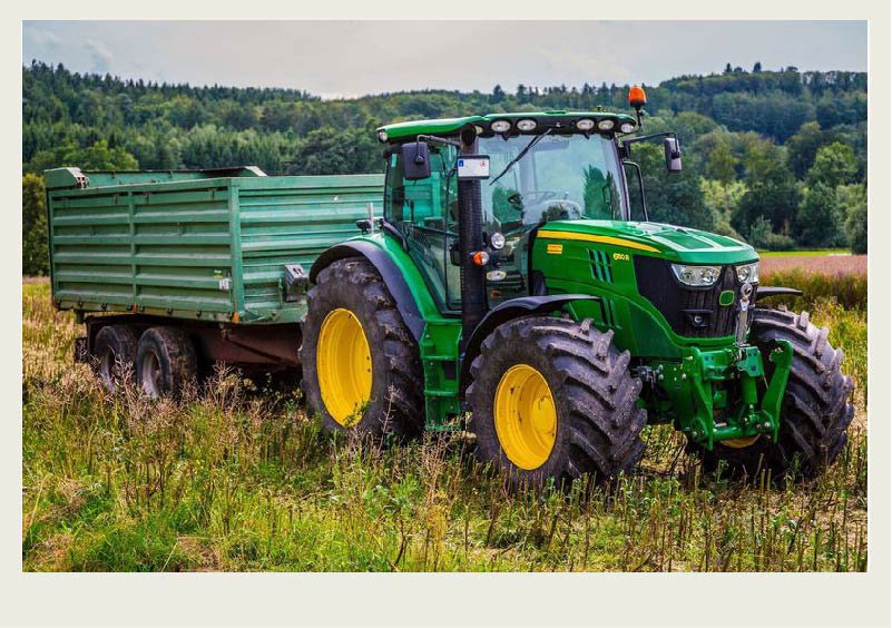 A tractor pulls a wagon in a field.