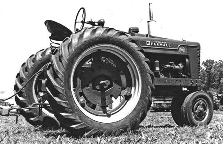 A Farmall tractor is parked in a farm field.
