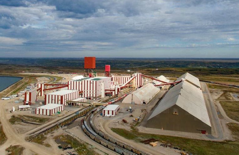 Evolution-Trade-NationalTrade-PotashMine An aerial view of a potash mine in Saskatchewan is shown with many buildings. There is also a railway coming into the mine with a train on it.