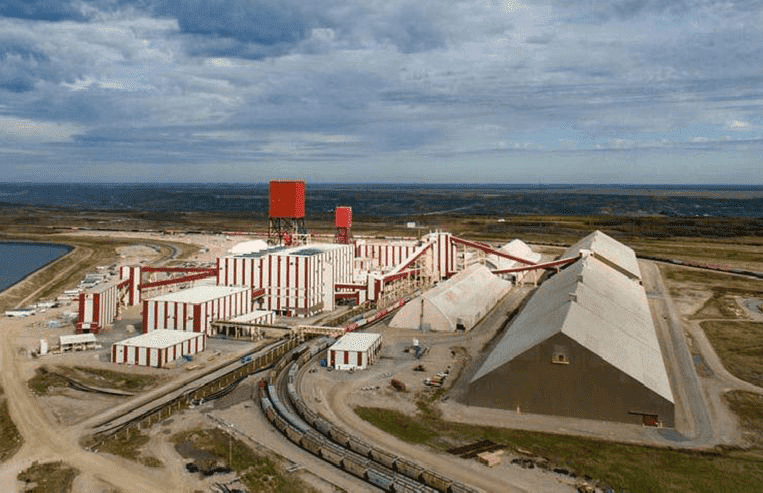 An aerial view of a potash mine is shown with many buildings, and a railway coming into it. 