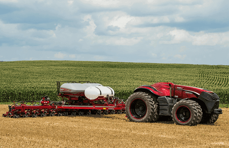 A tractor with no cab pulls a piece of equipment in the field.
