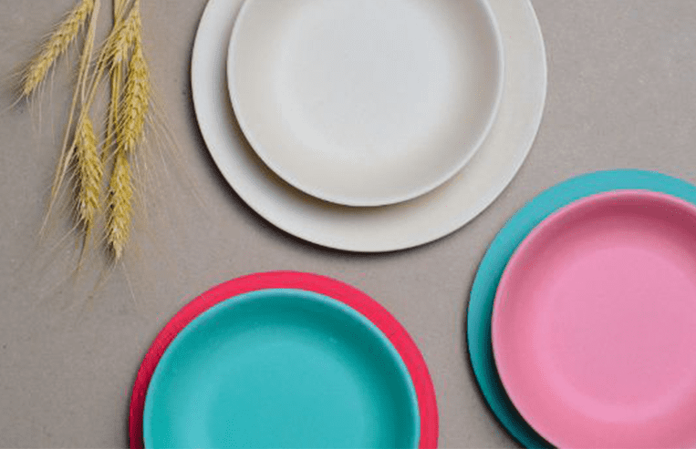 A grouping of plates is shown on a table, next to a wheat sheaf.