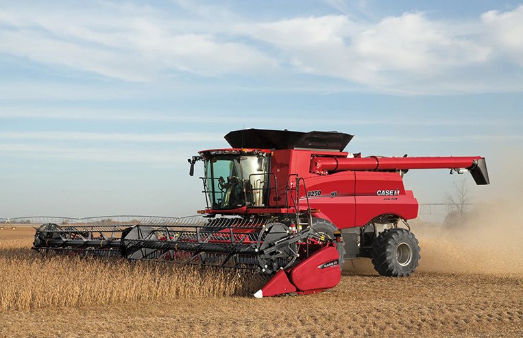 A combine harvests a golden-coloured crop with blue skies in the background.