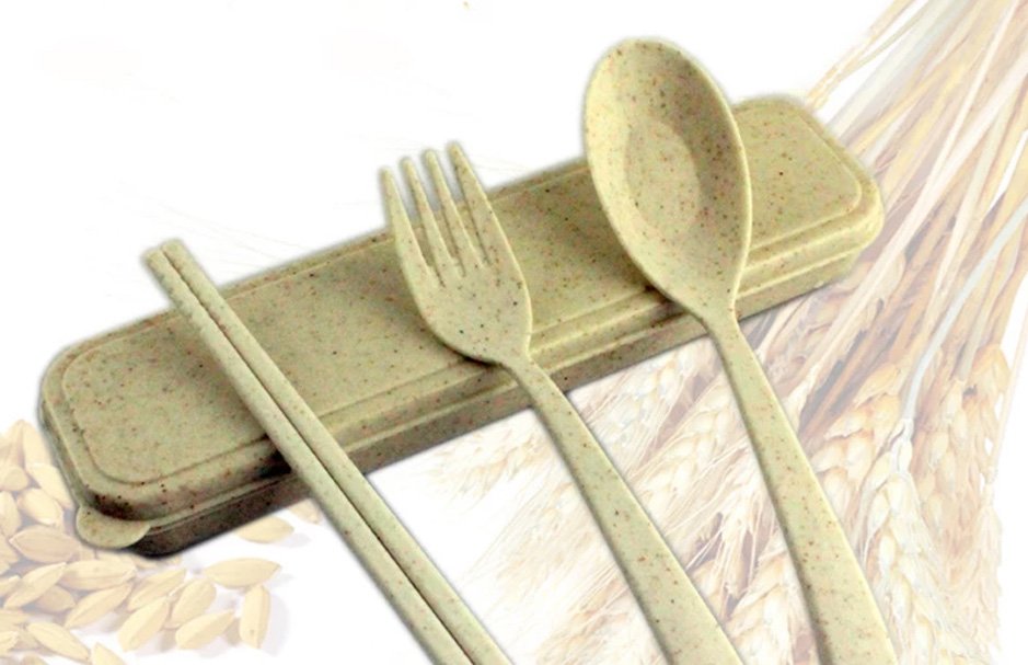 A plastic-looking fork, spoon, and chop sticks are shown with a sheaf of wheat in the background.