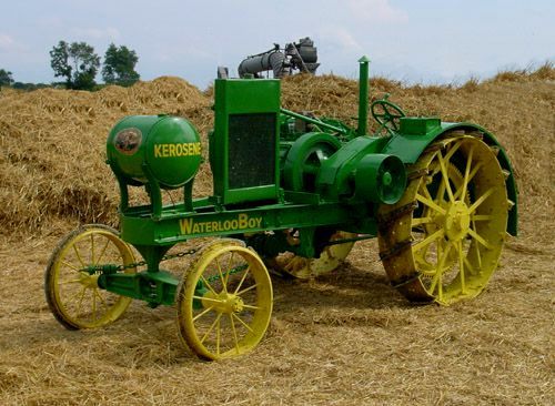 A green and yellow Waterloo Boy tractor with steel tires is shown.