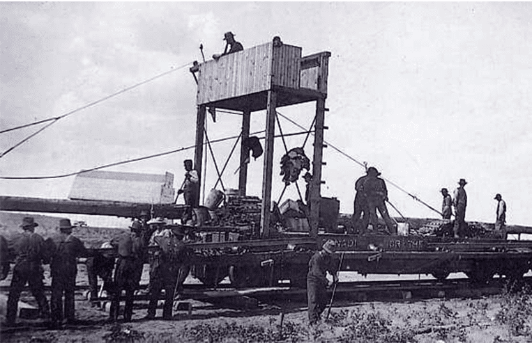 A group of men are working on a railway with tools in their hands.