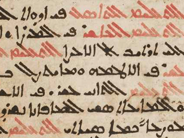 A First Nations man stands for a photo amongst a group of White men and women in formal wear.