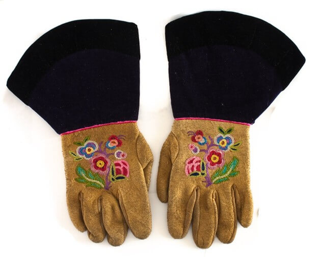 A piece of art by Leah Marie Dorion made with mosaics shows two Indigenous women facing each other with their hair blowing out behind them. There is a sun with butterflies in the centre, and snakes underneath the ground.