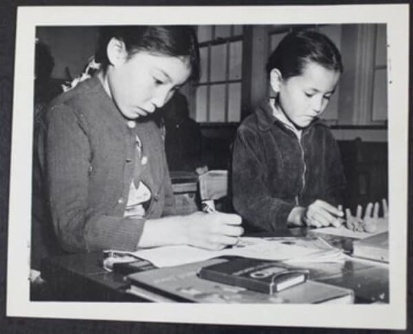 A piece of art by Leah Marie Dorion made with mosaics shows two Indigenous women facing each other with their hair blowing out behind them. There is a sun with butterflies in the centre, and snakes underneath the ground.