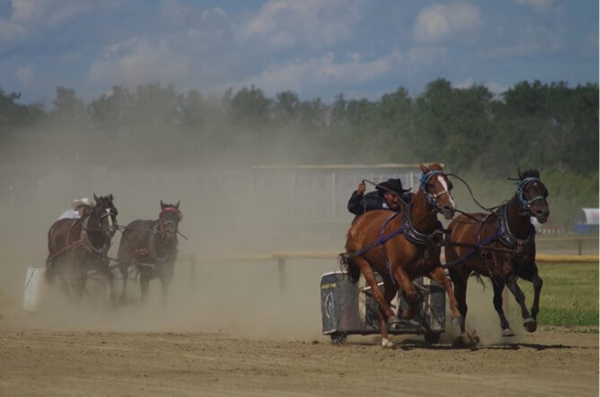 A piece of art by Leah Marie Dorion made with mosaics shows two Indigenous people standing near animals, sun, and water. 