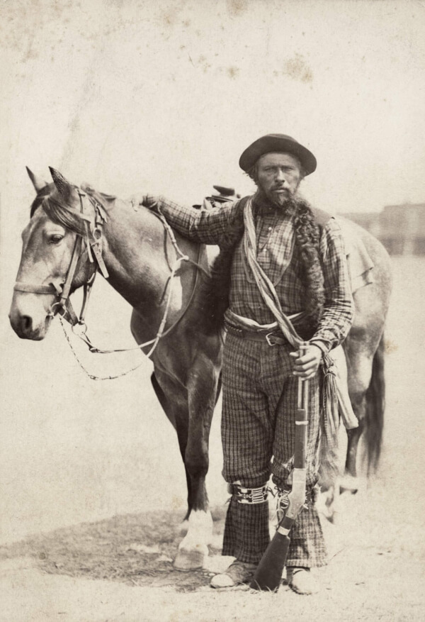 A piece of art by Leah Marie Dorion made with mosaics shows two Indigenous people standing near animals, sun, and water.